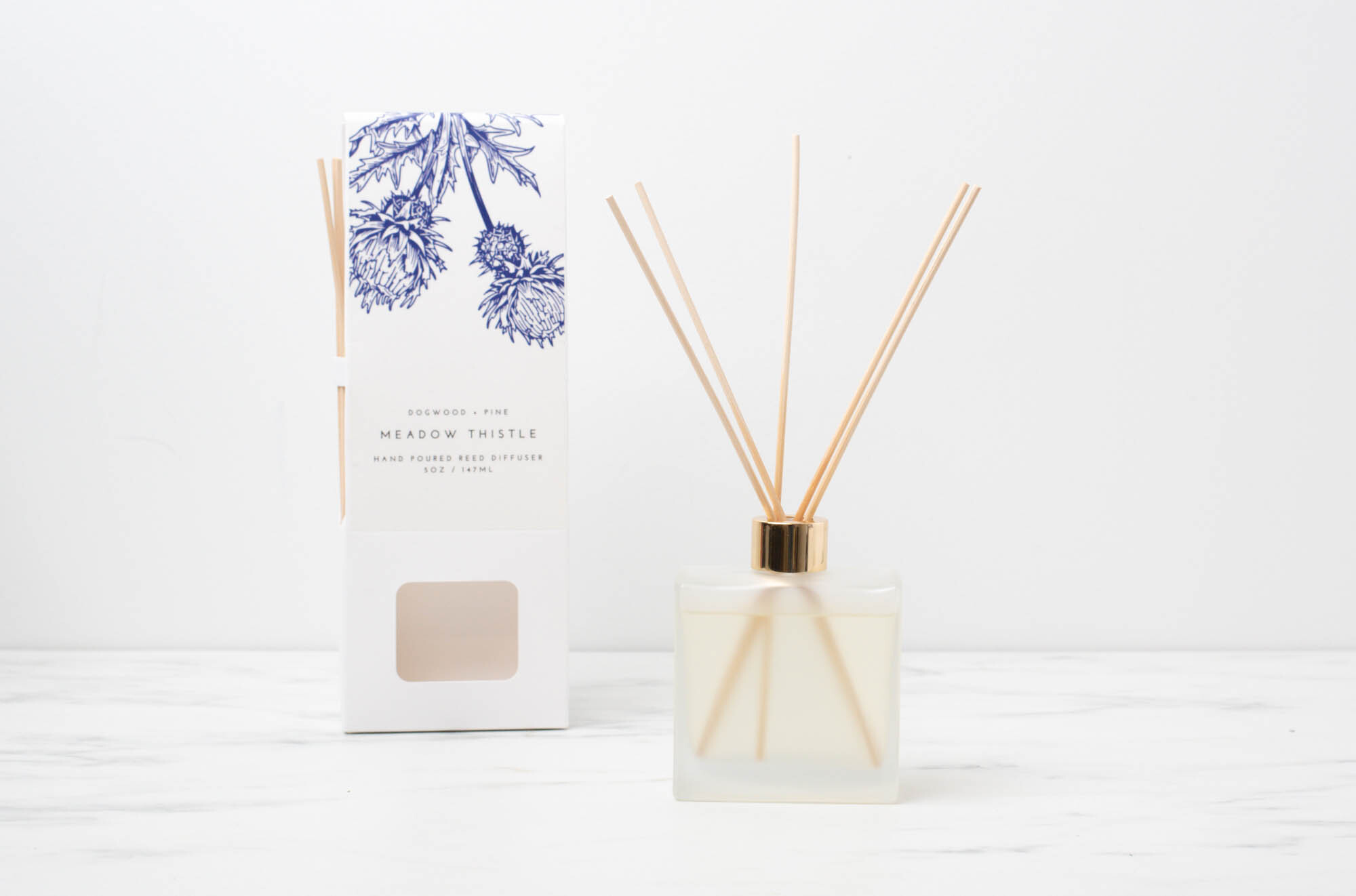 Finished reed diffuser next to a branded retail box.